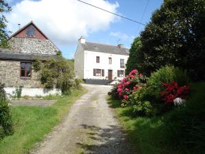 a dirt road in front of a white house at L'Ecurie in Saint-Ségal