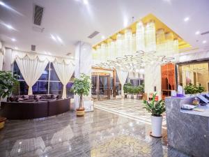 eine Lobby eines Hotels mit einem großen Zimmer mit Pflanzen in der Unterkunft Lavande Hotel Fangchenggang Administrative Center in Gongche