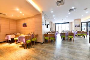 - un restaurant avec des tables et des chaises dans une salle dans l'établissement Lavande Hotel Huizhou High-speed Railway South Station Wanlian Square, à Huizhou