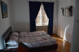 a bedroom with a bed in front of a window at Exit Labirint Centar in Novi Sad