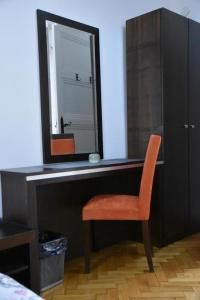 ein Spiegel auf einem Schreibtisch mit Stuhl in der Unterkunft Exit Labirint Centar in Novi Sad