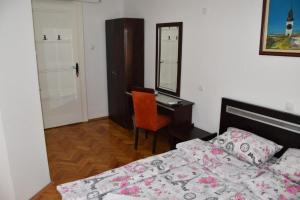 1 dormitorio con cama, escritorio y espejo en Exit Labirint Centar en Novi Sad
