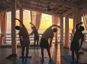蒙坦尼塔的住宿－蒙塔尼塔酒店，一群人在海滩上做瑜伽