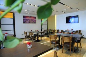 a restaurant with tables and chairs in a room at Lavande Hotel Tianshui Gangu Jicheng Square in Tianshui