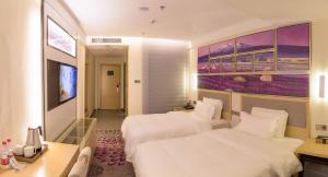 Cette chambre comprend deux lits et une télévision. dans l'établissement Lavande Hotel Luzhou Jiale Century City, à Luzhou