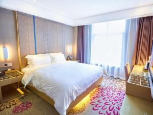 una camera con un grande letto e una grande finestra di Lavande Hotel ZhanJiang HaiBin Avenue Jiangnanshijia a Zhanjiang