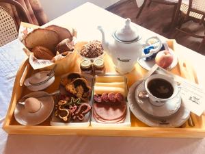 een dienblad met ontbijtproducten en koffie op een tafel bij Hotel Bergblick in Pomerode