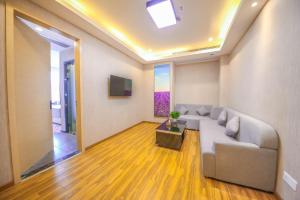 a living room with a couch and a television at Lavande Hotel Heyuan Zijin in Heyuan