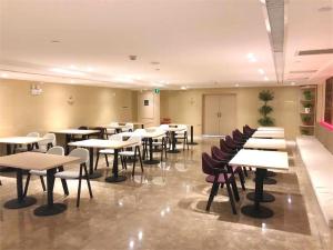 uma sala de aula com mesas e cadeiras numa sala em Lavande Hotel Turpan Grand Cross em Turfan