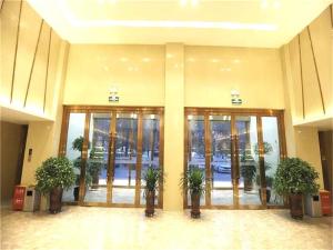 a lobby with glass doors and potted plants at Lavande Hotel Turpan Grand Cross in Turfan