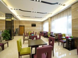 um restaurante com mesas e cadeiras num quarto em Lavande Hotel Qingyuan Flying Lake em Qingyuan