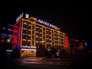 a large building with lights on it at night at Lavande Hotel Longnan Changjiang River Avenue in Longnan