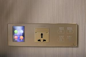 un dispositif électronique sur un mur avec une ipod dans l'établissement Lavande Hotel Chongqing Tongliang Wanda Plaza Gas Tower, à Tongliang