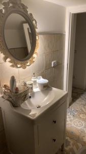 a bathroom with a white sink with a mirror at Il giardino segreto in Taranto +50 photos
