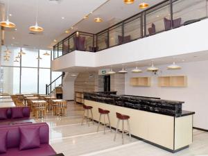 un ristorante con bar con sedie e tavoli di Lavande Hotel Zhanjiang Xuwen Tianrunhui a Xuwen