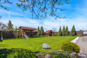 a yard with a playground and a gazebo at Jūratės B&B Namai in Karmėlava