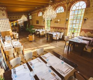 restauracja ze stołami i krzesłami oraz żyrandolem w obiekcie Cuisinerie Mensinge With Dreams w mieście Roden