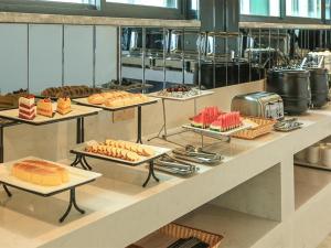 uma linha de buffet com diferentes tipos de alimentos em bandejas em Lavande Hotel Zhengzhou Longhai West Road Subway Station em Zhengzhou