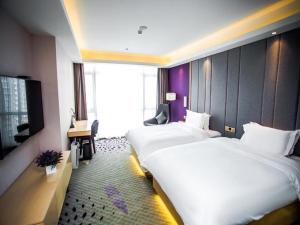 a hotel room with two beds and a tv at Lavande Hotel Yanan Pagoda Mountain in Yan'an