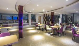 a restaurant with tables and chairs and a kitchen at Lavande Hotel Yingde Yingzhou Avenue in Yingde