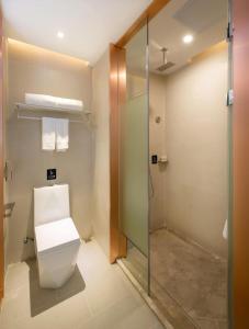 a bathroom with a toilet and a glass shower at Lavande Hotel Yingde Yingzhou Avenue in Yingde