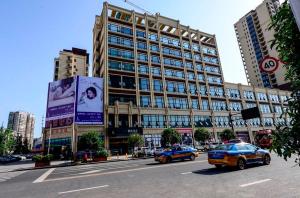 a large building with cars driving in front of it at Lavande Hotel Neijiang High-speed Railway Station Peace Plaza in Neijiang