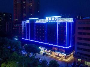 a building with a blue lit up sign on it at Lavande Hotel Qingyuan Municipal Government New Town Bus Station in Qingyuan
