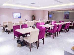 uma sala de jantar com mesas e cadeiras roxas em Lavande Hotel Korla city government swan lake em Korla