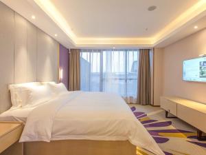 a bedroom with a large white bed and a flat screen tv at Lavande Hotel Chongqing Jiangbei International Airport Center in Yubei