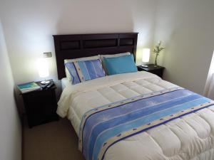 1 dormitorio con 1 cama grande y 2 mesitas de noche en Departamento Aquamar, en Viña del Mar