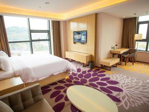 a hotel room with a large bed and a desk at Lavande Hotel Mianyang Santai North Passenger Transport Center Binjiang Park in Mianyang