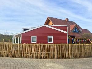 a red house behind a wooden fence at Tinyhouse Bamberg in Pettstadt
