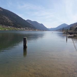 a pole in the middle of a body of water at Ferienhof Alte Post, Apartments in Weissbriach