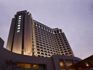 a tall building with a sign on the side of it at Pullman Dongguan Changan in Dongguan