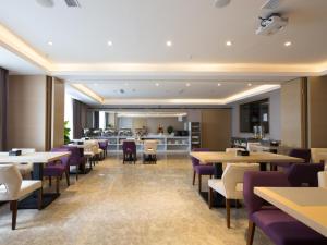 um restaurante com mesas e cadeiras e um balcão em Lavande Hotel Qijiang High-speed Railway Station em Qijiang