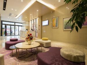 a lobby with purple and white furniture and a table andools at Lavande Hotel Qijiang High-speed Railway Station in Qijiang