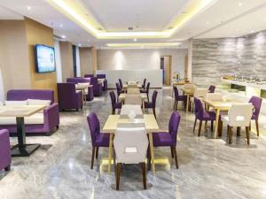 uma sala de jantar com mesas e cadeiras roxas em Lavande Hotel Bazhong Fortune Center em Bazhong