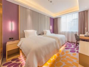 two beds in a hotel room with purple walls at Lavande Hotel Zhongshan Tanzhou in Zhongshan +58 photos