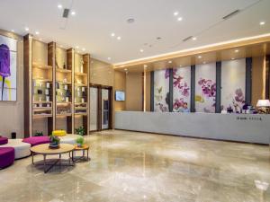 a lobby of a hotel with purple furniture and a counter at Lavande Hotel Yibin University City Exhibition Center in Yibin