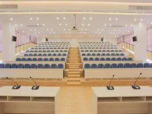 an empty lecture hall with blue chairs and tables at Lavande Hotel Dongguan Liaobu Center in Dongguan