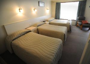 a hotel room with two beds and two night stands at Motel Wingrove in Corowa