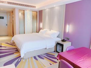 a bedroom with a white bed and purple walls at Lavande Hotel Huizhou Xinxu Government Square in Niu'ao +28 photos