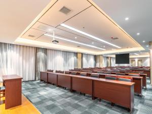 une salle de conférences avec des rangées de bureaux et un écran dans l'établissement Lavande Hotel Anshun West High-speed Rrailway Station, à Anshun