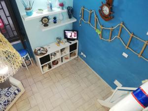 ein Zimmer mit einer blauen Wand mit einem Regal und einer Uhr in der Unterkunft Sky Blue Dreams Holiday Home in Catania