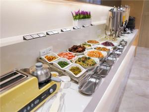 a buffet line with many different dishes of food at Lavande Hotel Urumqi Beijing South Road Railway Bureau Subway Station in Ürümqi