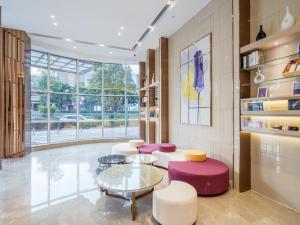 - un hall avec des chaises violettes et une table en verre dans l'établissement Lavande Hotel Luzhou Wanda Plaza Southwest Commercial City, à Luzhou