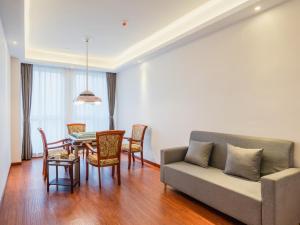 a living room with a couch and a table and chairs at Lavande Hotel Luzhou Wanda Plaza Southwest Commercial City in Luzhou