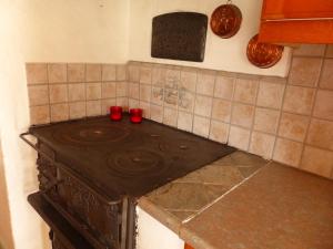 a stove in a kitchen with two red cups on it at Ferienhaus Björkebo in Stöllet +29 photos