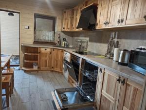 a kitchen with wooden cabinets and a dishwasher at Brand NEW 2020 specious apartments DRUZI 3 in Bukovel