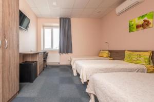 a hospital room with three beds and a tv at Air Kaunas in Karmėlava